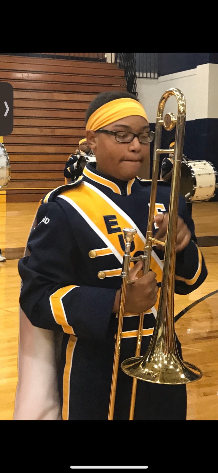 Young musician in marching band uniform holding a trombone — Earnie's Light youth music outreach